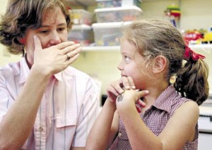 4/23/2001 - - TAMPA - - CAPTION INFO: DIGITAL IMAGES: (2) Auditory / Verbal Therapist Tina LeVasseur (cq / 30 yrs.old / left) covers her mouth so Louie Alvarez (cq / 6 yrs.old / right) can't read her lips. They were playing a game to help Louie form sentences. **** The Oscar-nominated documentary "Sound and Fury" will be shown Thursday at Tampa Theater. It deals with the controversy in the deaf world over cochlear implants, medical devices that help deafpeople hear. Some in deaf community say this is bad, that it robs deaf people of their identity and treats deafness as something to 'fix'. Implant supporters think it's a medical miracle. Suzanne Alvarez is one of them. She brings her deaf daughter, Louie, 6, to the Bolesta Center for verbal therapy. Louie had the implant 4 yrs ago. She's doing well. - - Times Photo by: Ken Helle - - Story By: Jeanne Malmgren - - SCANNED BY: kh - - RUN DATE: 4/26/2001